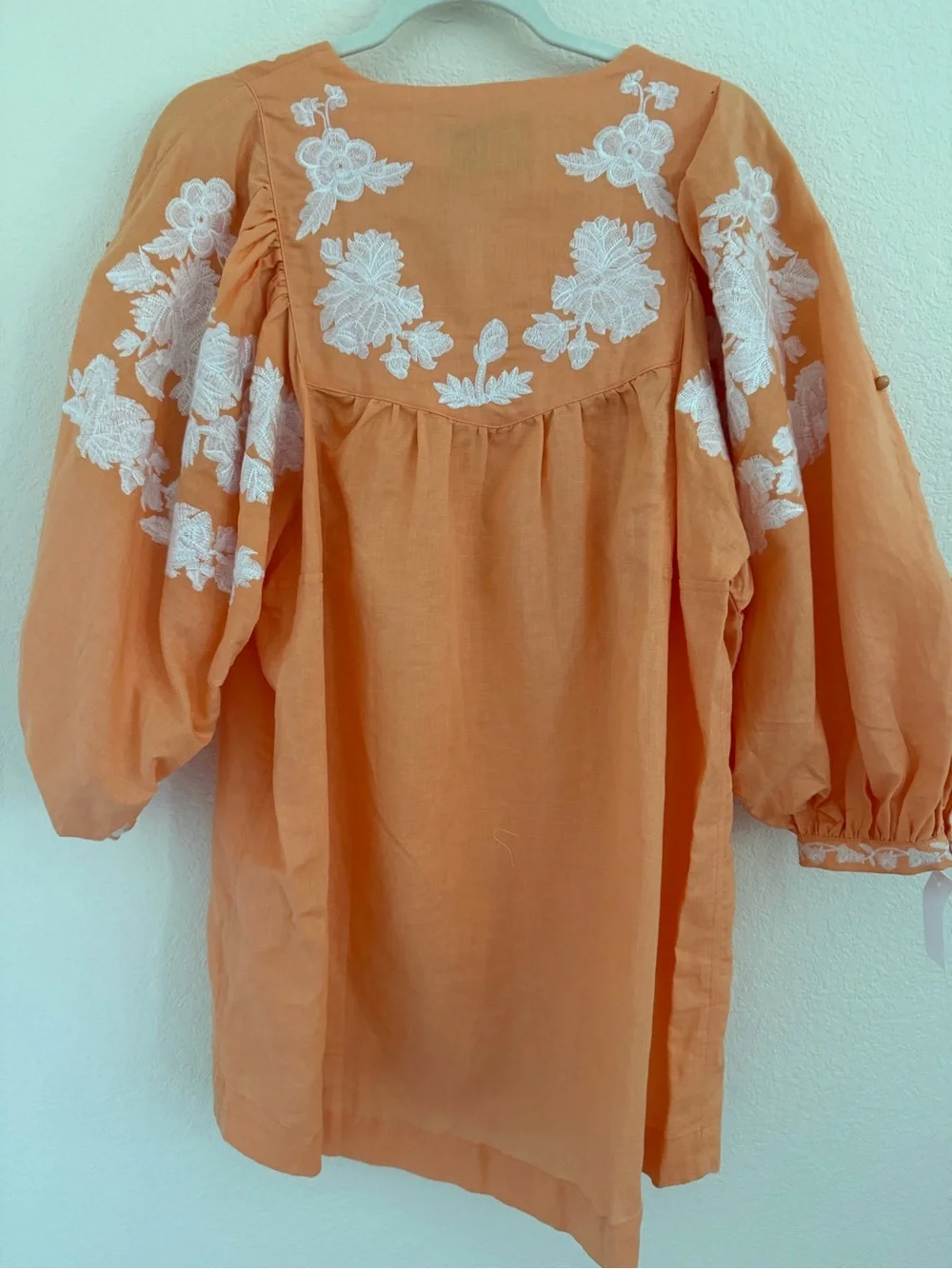 Blouse features split neckline with ties and voluminous embroidered puff sleeves